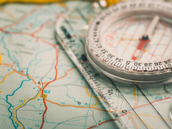 A map with a compass and ruler on top, used for navigation and orientation.